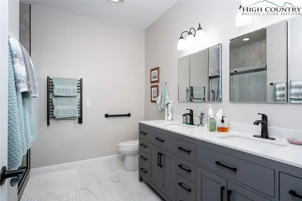 a bathroom with a double vanity sink mirror and toilet