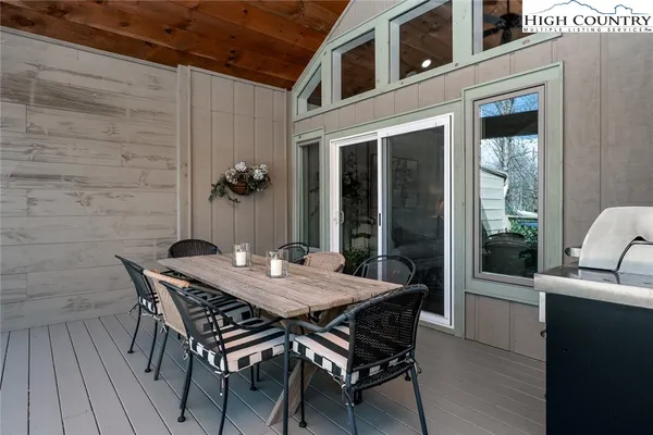 a view of a balcony with chairs and wooden floor