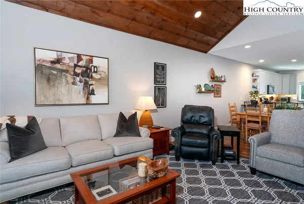 a living room with furniture a rug and a painting