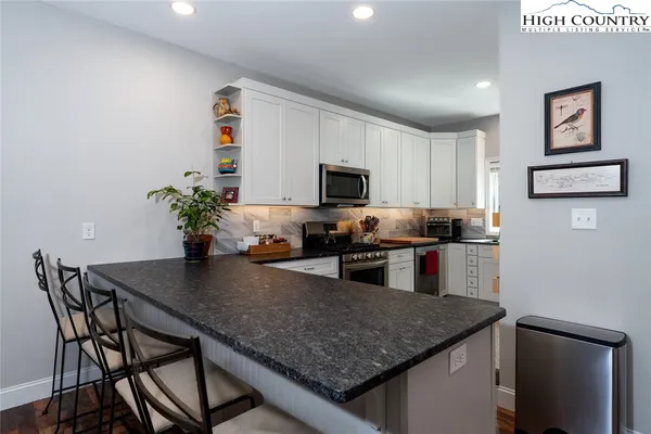 a kitchen with stainless steel appliances granite countertop sink stove top oven and microwave