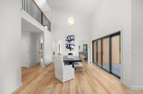 a dining room with furniture entryway and wooden floor
