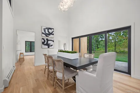 a dining room with furniture a large window and wooden floor