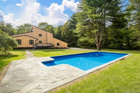 a view of a house with swimming pool and yard