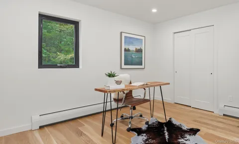 a view of a workspace with furniture and a window