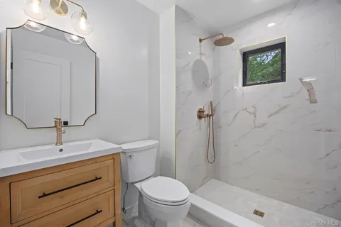 a bathroom with a sink a toilet and shower