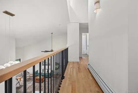 a view of a hallway with wooden floor and staircase
