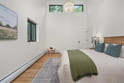 a bedroom with a bed and painting on the wall