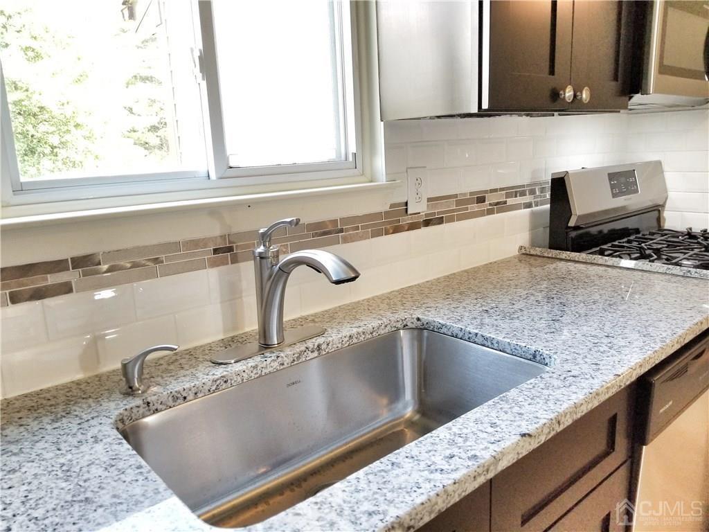 8503 Hana Road Edison, NJ 08817 - Photo 13 of 18 a kitchen with granite countertop a sink and a stove