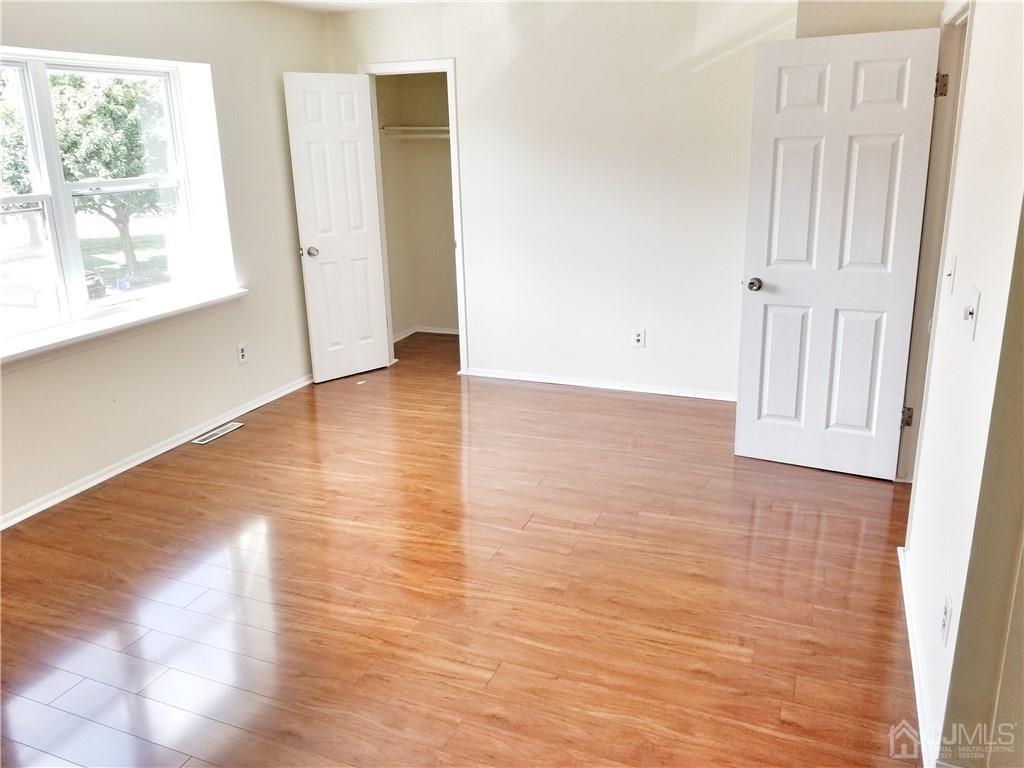 8503 Hana Road Edison, NJ 08817 - Photo 16 of 18 a view of an empty room with wooden floor and a window