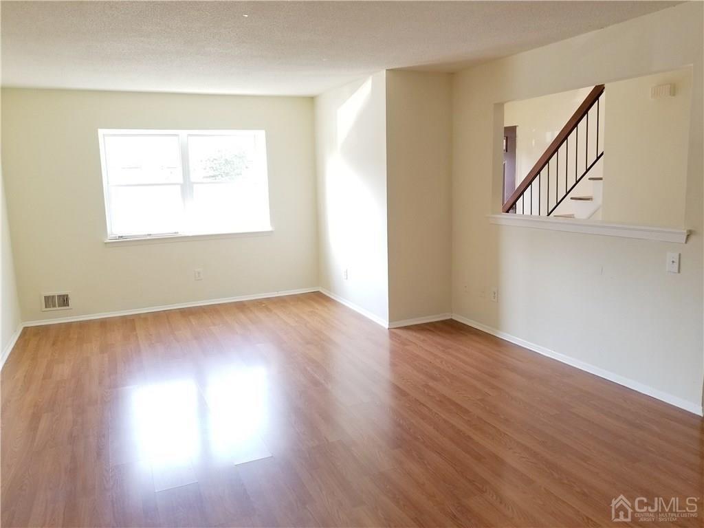 8503 Hana Road Edison, NJ 08817 - Photo 9 of 18 an empty room with wooden floor and windows