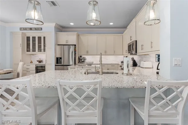 a large kitchen with kitchen island granite countertop a sink cabinets and stainless steel appliances
