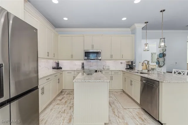 a kitchen with a sink a counter top space stainless steel appliances and cabinets