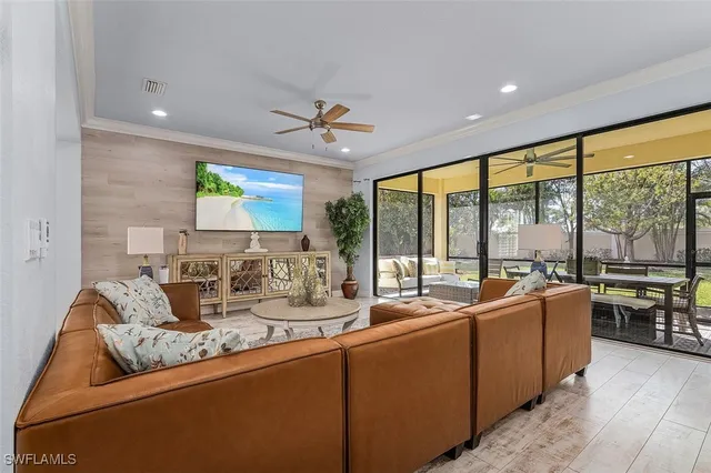 a living room with stainless steel appliances kitchen island furniture and a large window