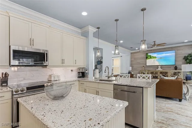 a kitchen with stainless steel appliances granite countertop a sink stove and microwave