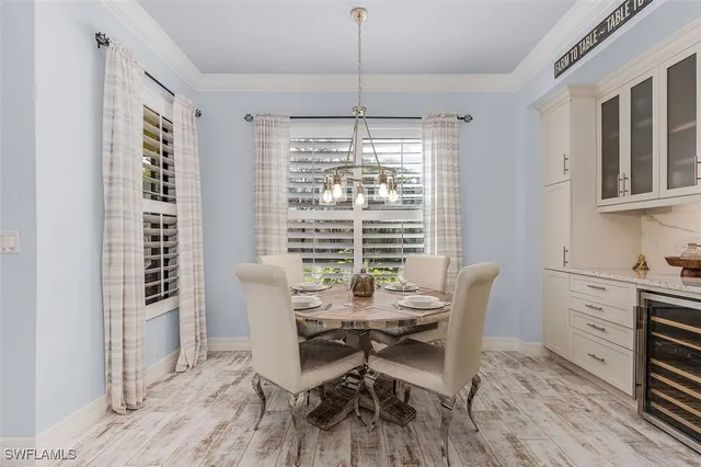a dining room with furniture a chandelier and wooden floor
