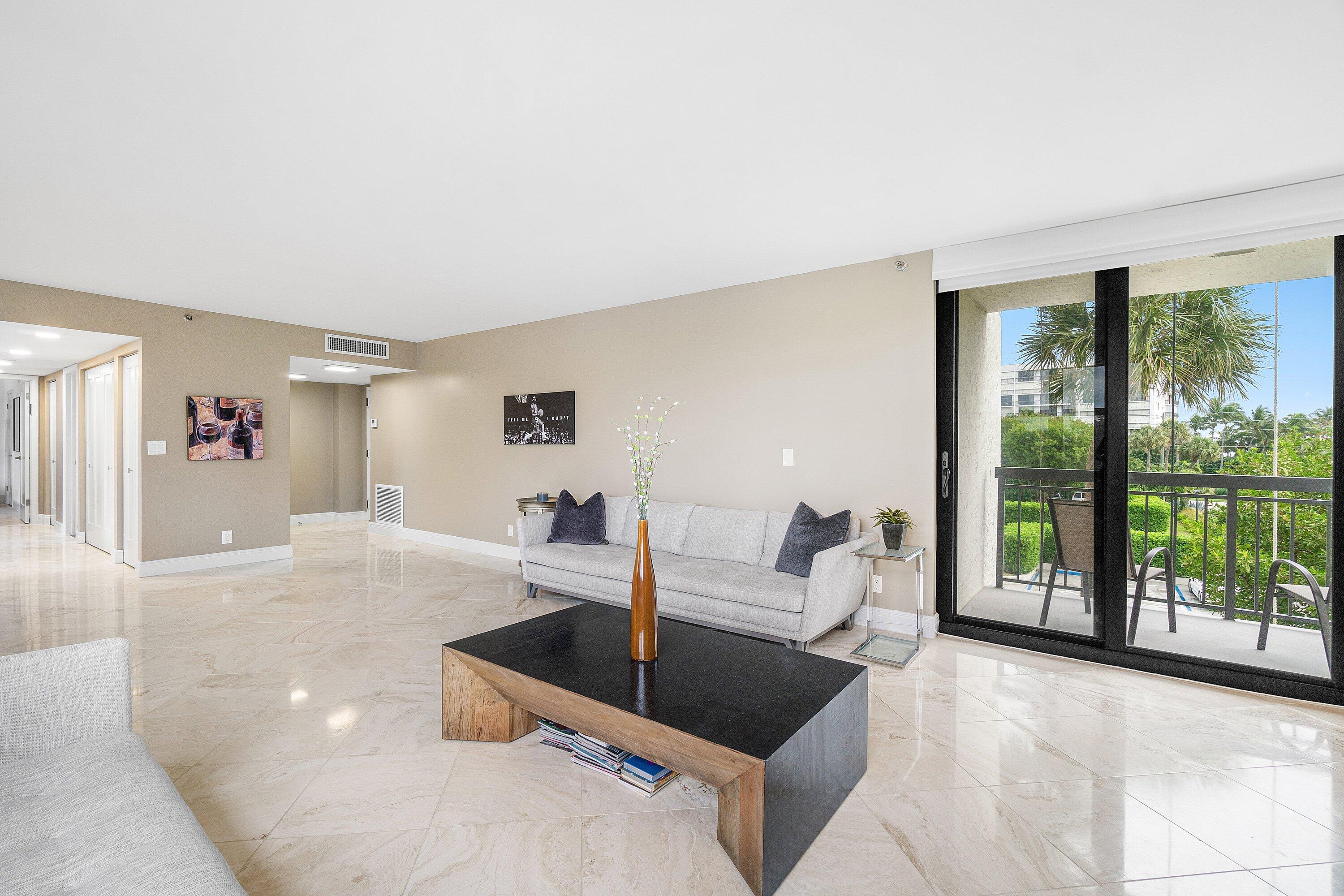 2001 North Ocean Boulevard, Unit 305 Boca Raton, FL 33431 - Photo 14 of 61 a living room with furniture and large windows