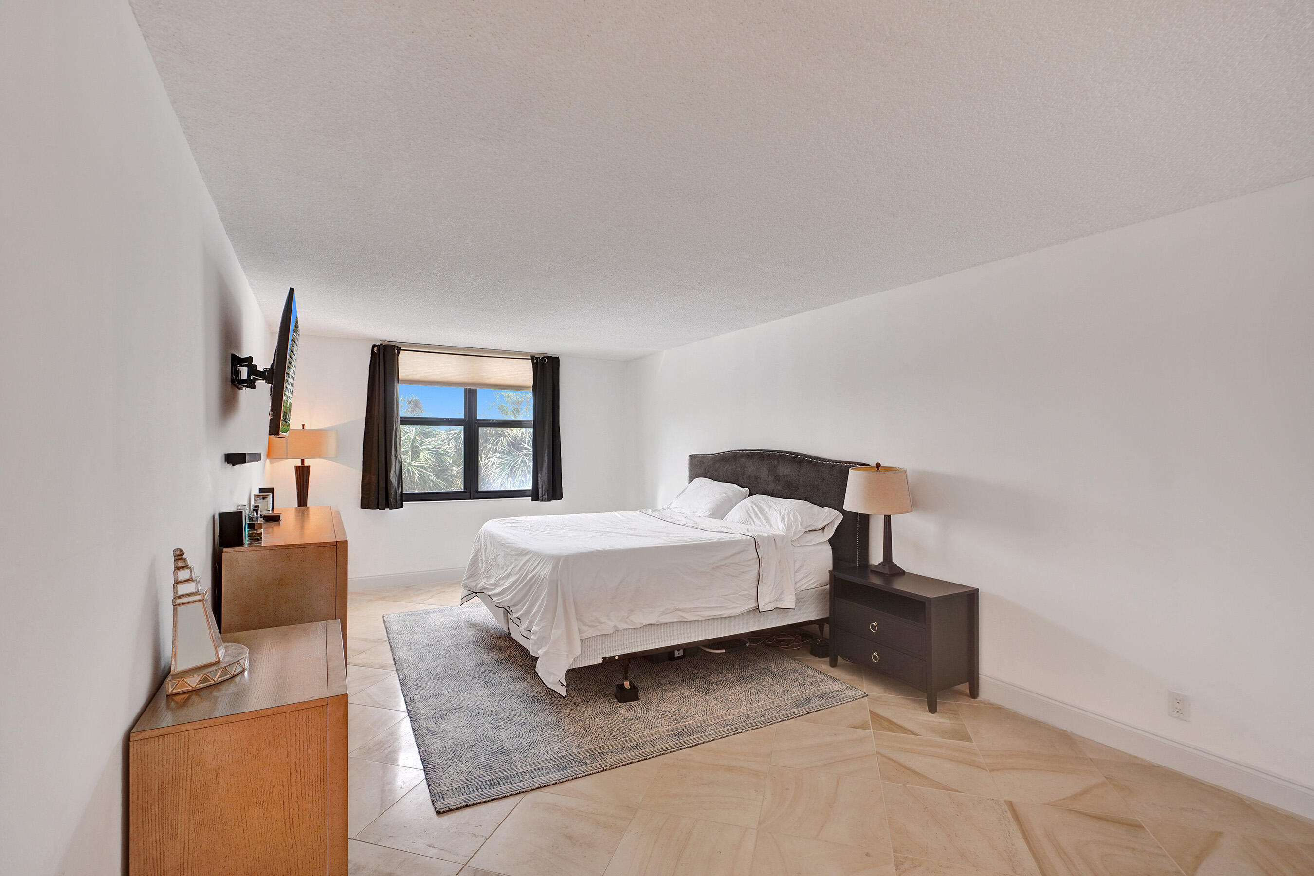 2001 North Ocean Boulevard, Unit 305 Boca Raton, FL 33431 - Photo 37 of 61 a spacious bedroom with a bed and a large window