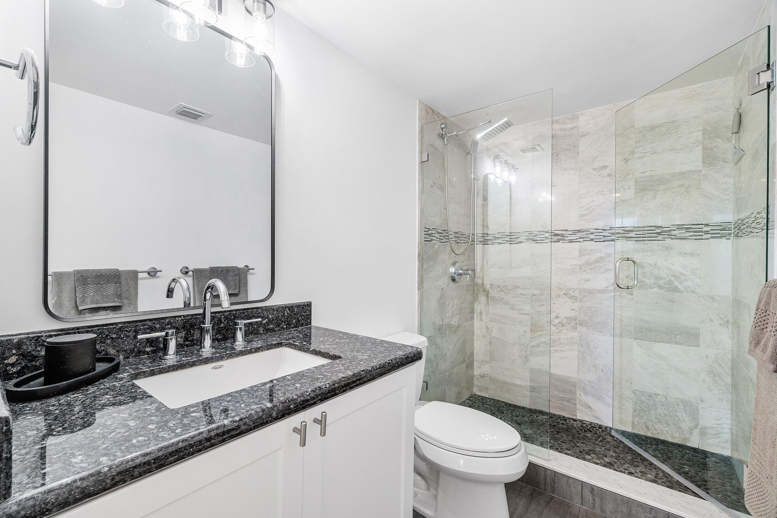 2001 North Ocean Boulevard, Unit 305 Boca Raton, FL 33431 - Photo 48 of 61 a bathroom with a granite countertop sink a toilet a mirror and shower