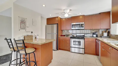 a kitchen with cabinets a counter and chairs