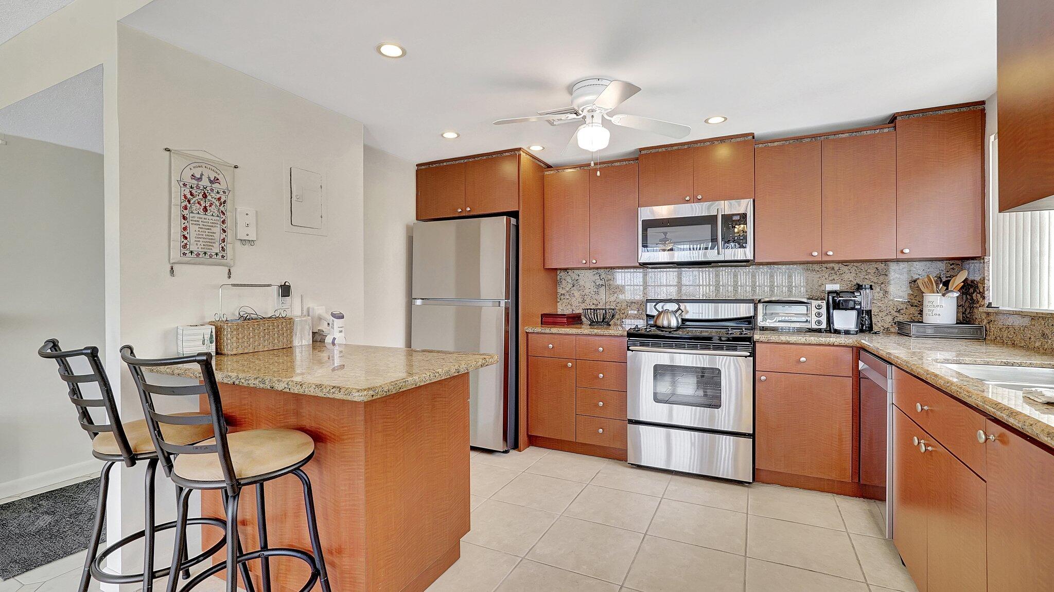 1825 South Ocean Drive, Unit 908 Hallandale Beach, FL 33009 - Photo 9 of 20 a kitchen with cabinets a counter and chairs