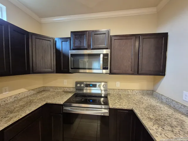 a kitchen with granite countertop cabinets and oven