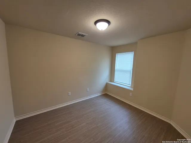 a view of an empty room with wooden floor