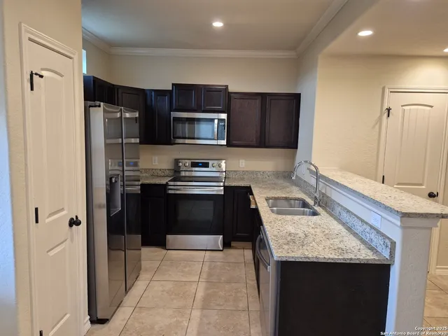 a kitchen with stainless steel appliances granite countertop a refrigerator stove and sink