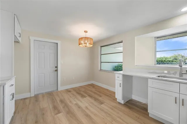 an empty room with wooden floor and ceiling fan