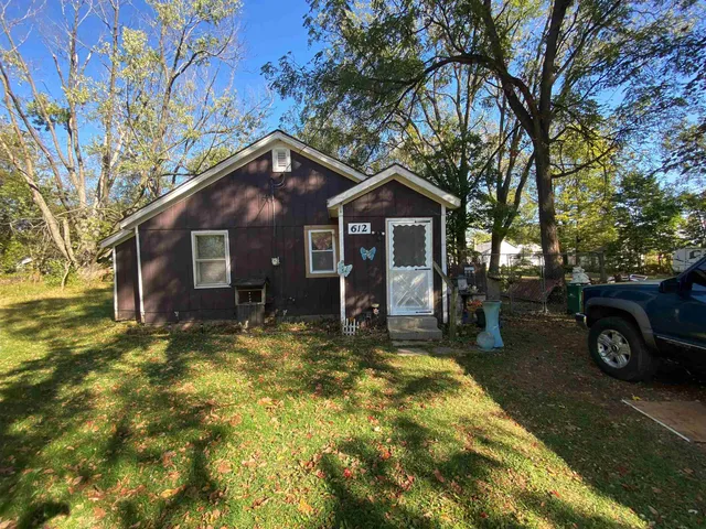 a view of a house with a big yard and large tree