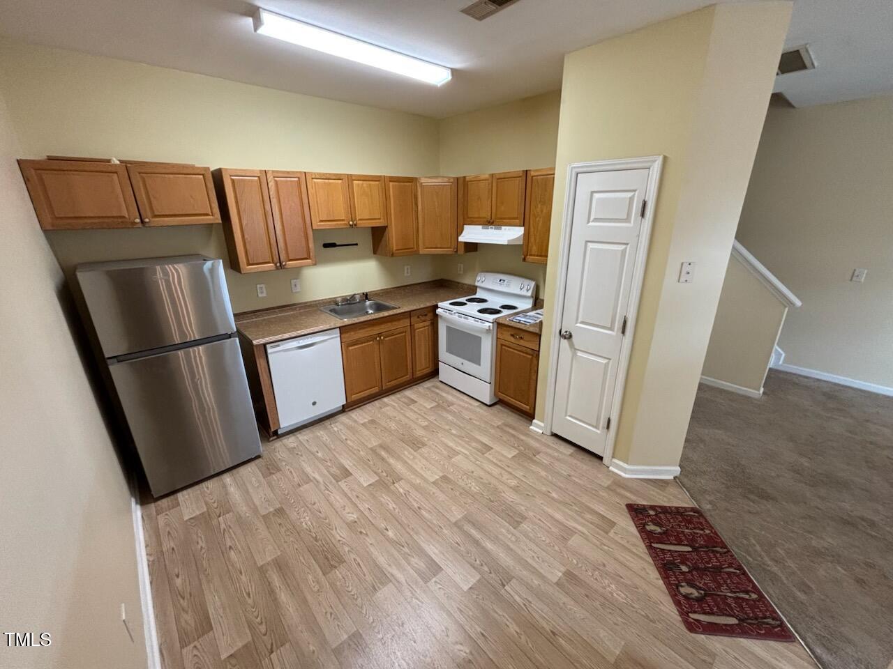 1311 Canyon Rock Court, Unit 105 Raleigh, NC 27610 - Photo 4 of 11 a kitchen with stainless steel appliances granite countertop a refrigerator stove and sink