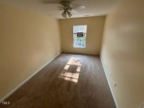 an empty room with windows and ceiling fan view
