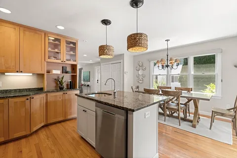 a kitchen with stainless steel appliances granite countertop a stove and a wooden floors