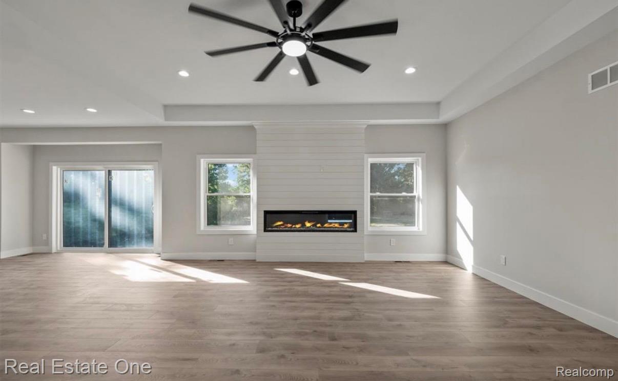 5636 Paris Street Sterling Heights, MI 48310 - Photo 6 of 37 Unfurnished living room featuring dark wood-style flooring, a fireplace, recessed lighting, and a ceiling fan