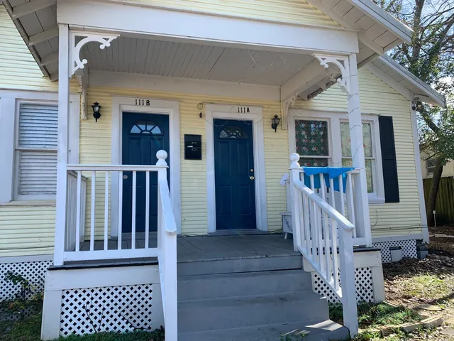 front view of a house with wooden fence and large windows