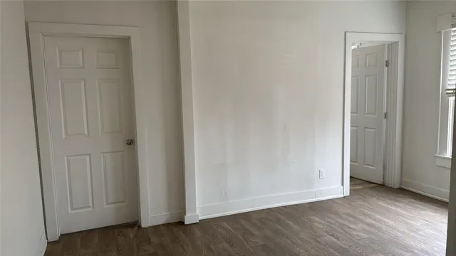 a view of an empty room and wooden floor & entryway