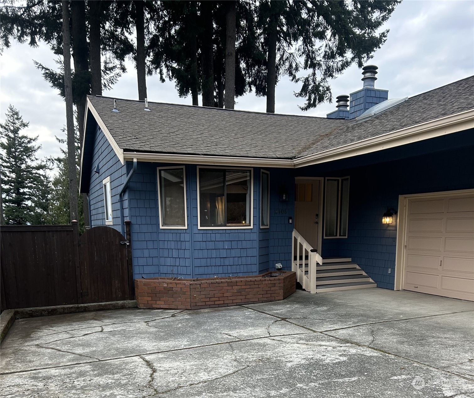 a view of a house with a yard and wooden fence