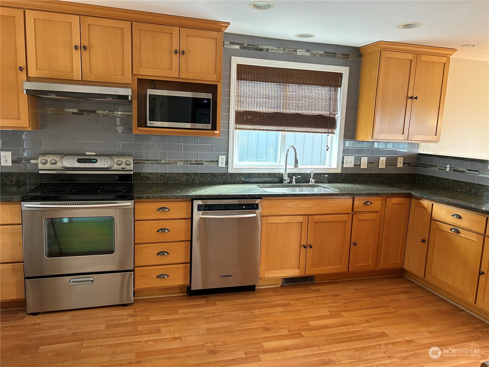 2106 37th Street Bellingham, WA 98229 - Photo 6 of 32 a kitchen with stainless steel appliances granite countertop a stove a sink and a microwave