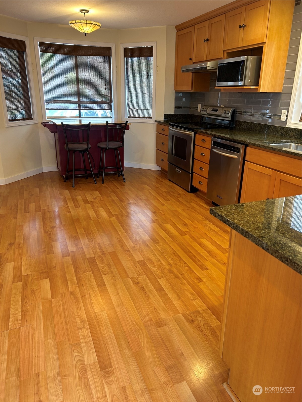 2106 37th Street Bellingham, WA 98229 - Photo 9 of 32 a kitchen with stainless steel appliances kitchen island granite countertop a stove a sink and a microwave
