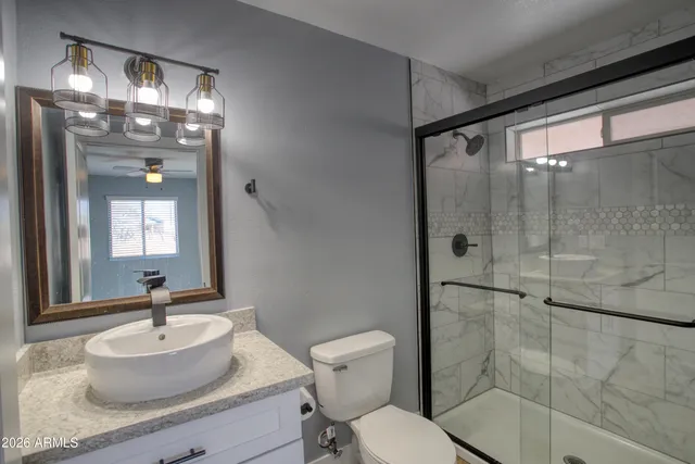 a bathroom with a sink toilet a mirror and shower