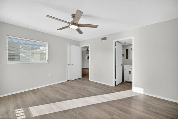 a view of a big room with wooden floor and windows