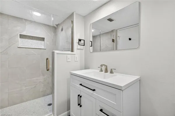 a bathroom with a sink a shower a mirror and a shower