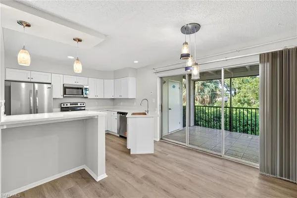 a kitchen with stainless steel appliances granite countertop a refrigerator and a stove top oven