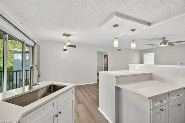 a kitchen with a sink a refrigerator and chandelier