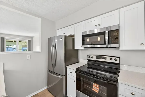 a kitchen with stainless steel appliances white cabinets and a stove top oven