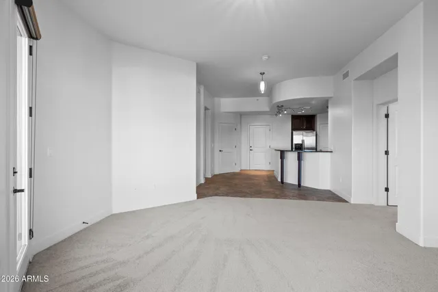 a view of empty room with a kitchen