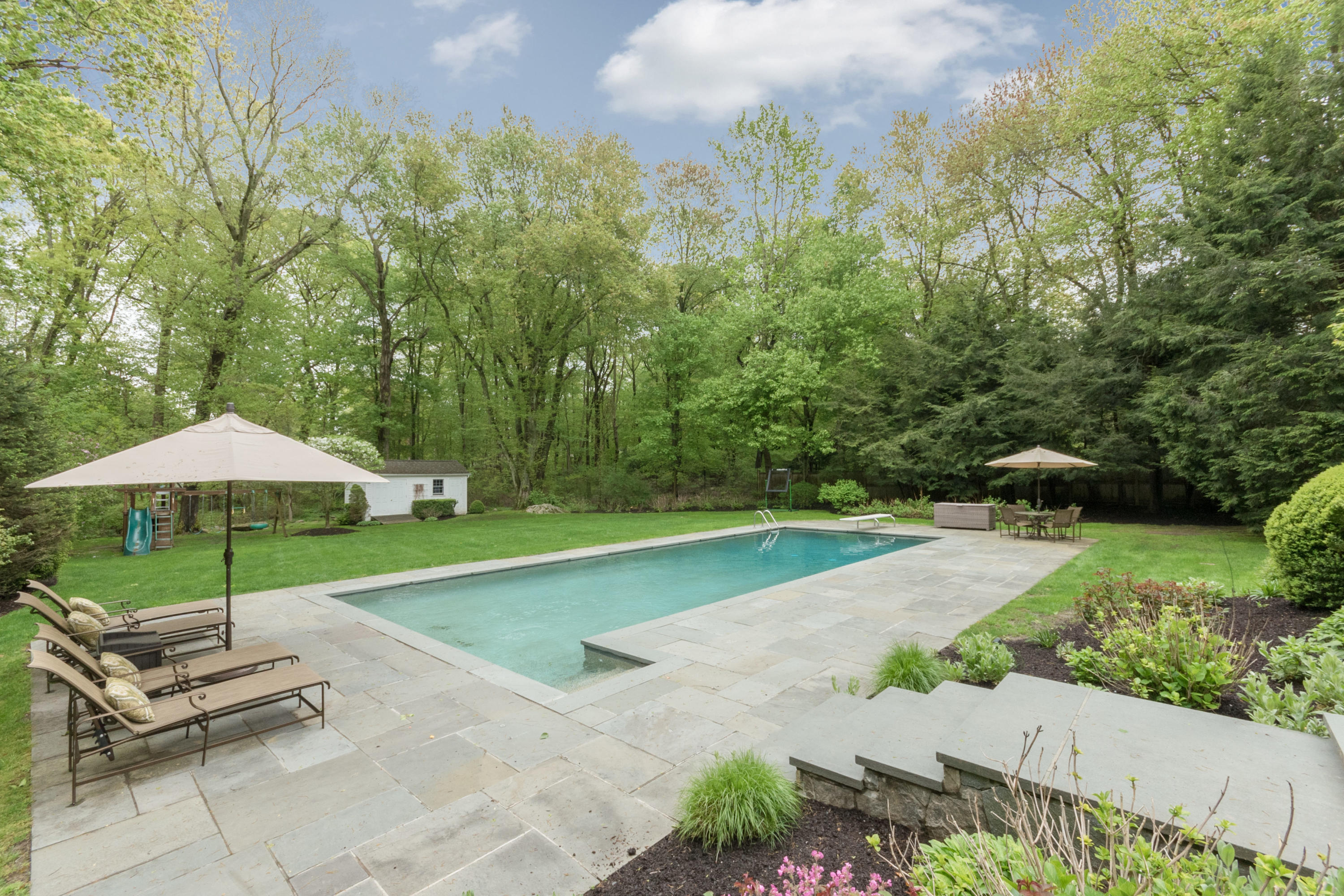 280 Hollow Tree Ridge Road Darien, CT 06820 - Photo 57 of 66 a view of a patio with a table and chairs under an umbrella