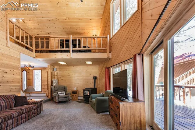 a living room with furniture a flat screen tv and a floor to ceiling window