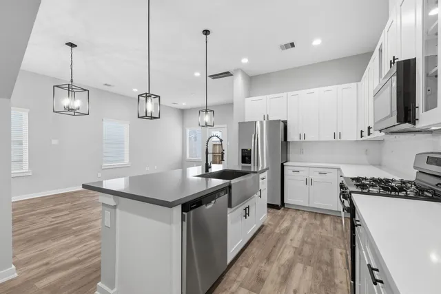 a kitchen with stainless steel appliances granite countertop a sink a stove and a refrigerator