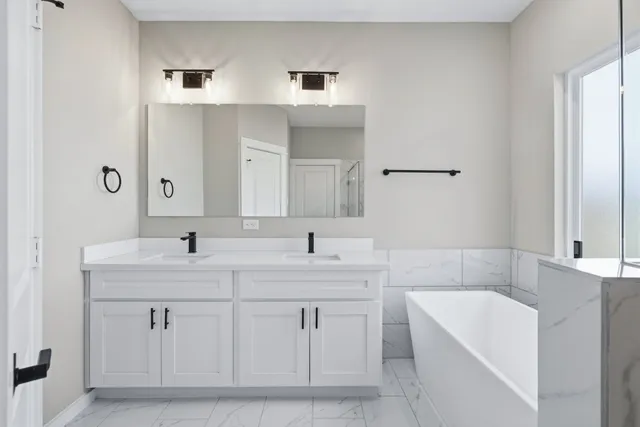 a bathroom with a tub a sink and mirror
