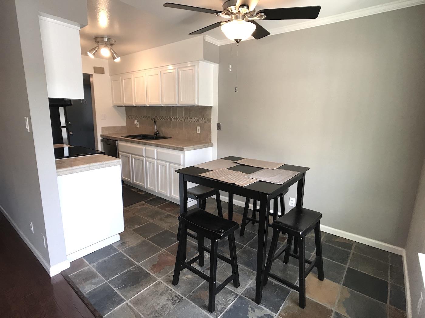 1925 46th Avenue, Unit 60 Capitola, CA 95010 - Photo 1 of 26 a kitchen with a dining table chairs and white cabinets